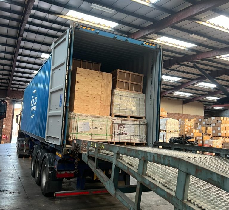 A blue shipping container loaded with wooden crates inside a warehouse. A blue shipping container loaded with wooden crates inside a warehouse.